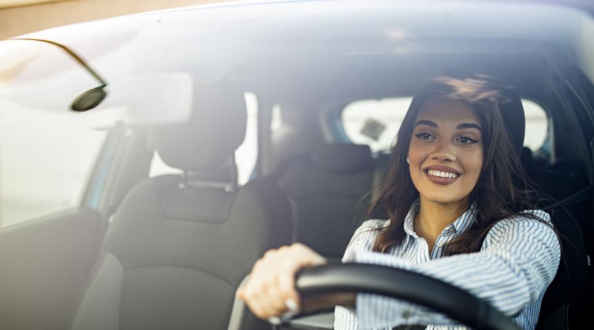 Woman smiling and driving a car