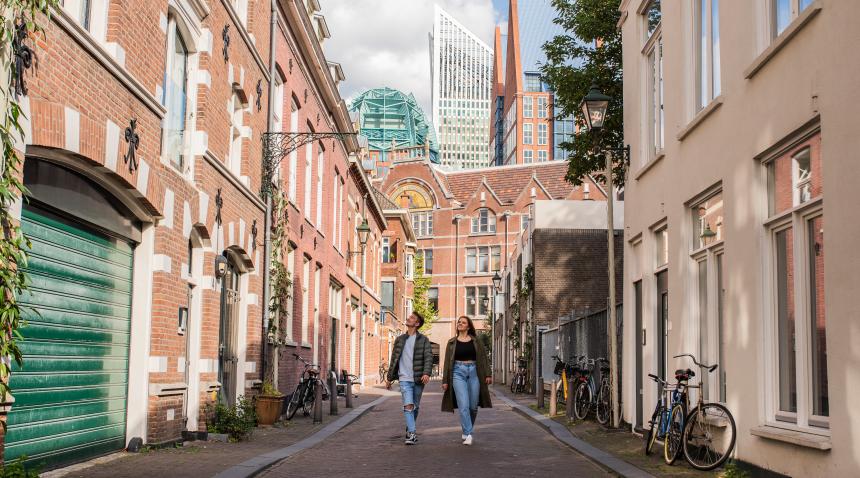 jong stel in de Korte Koediefstraat kijkend naar de oude en nieuwe architectuur in het centrum van Den Haag
