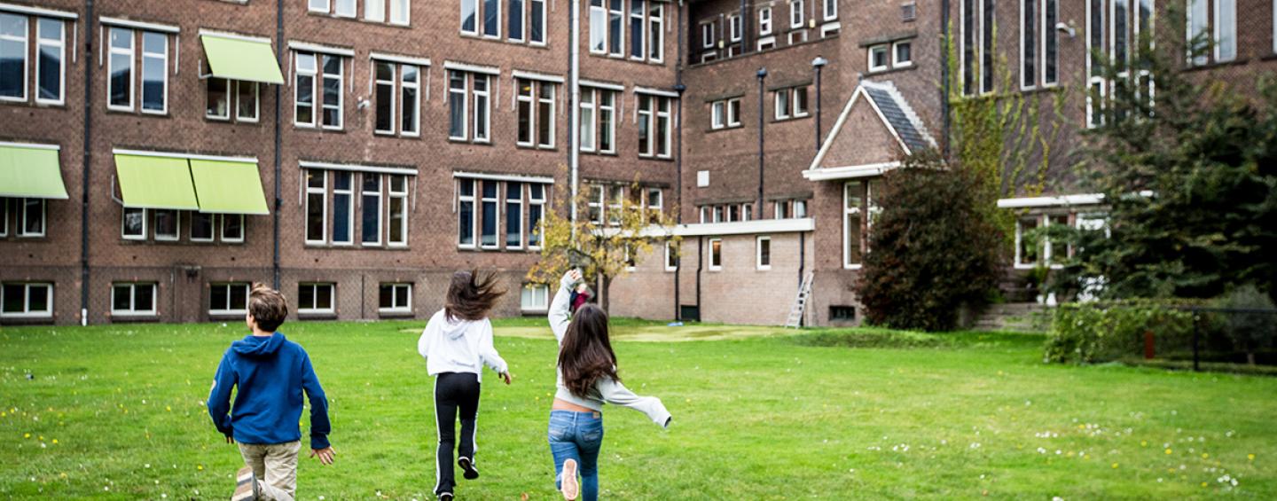 Children running toward a school