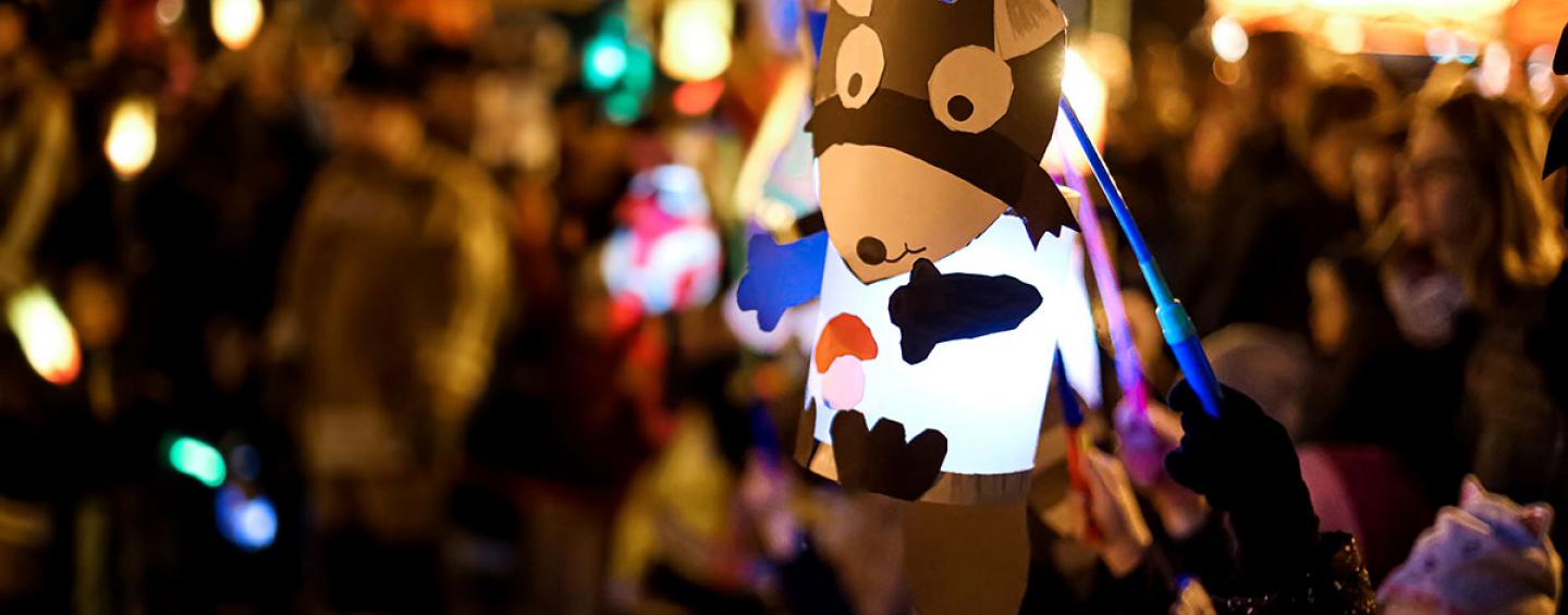 Child holding up a hand-made lantern