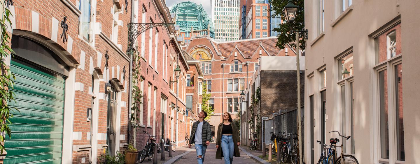 jong stel in de Korte Koediefstraat kijkend naar de oude en nieuwe architectuur in het centrum van Den Haag