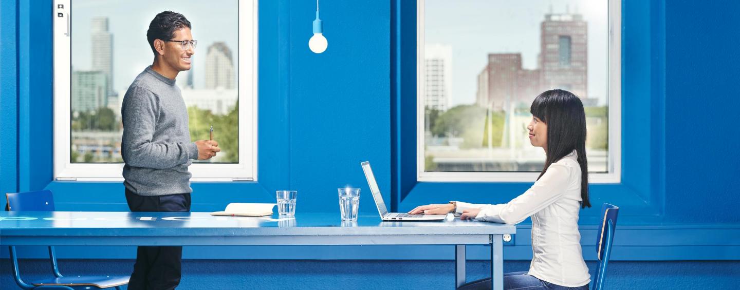 lady sitting behind a laptop in a blue office